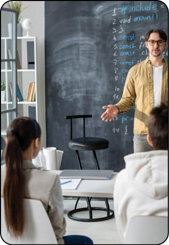 Confident teacher of modern technology course standing against blackboard in front of audience and explaining lesson points