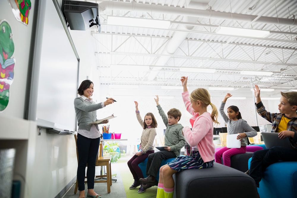 teacher pointing to students with arms raised 533978201 5919f9935f9b58f4c09a895a