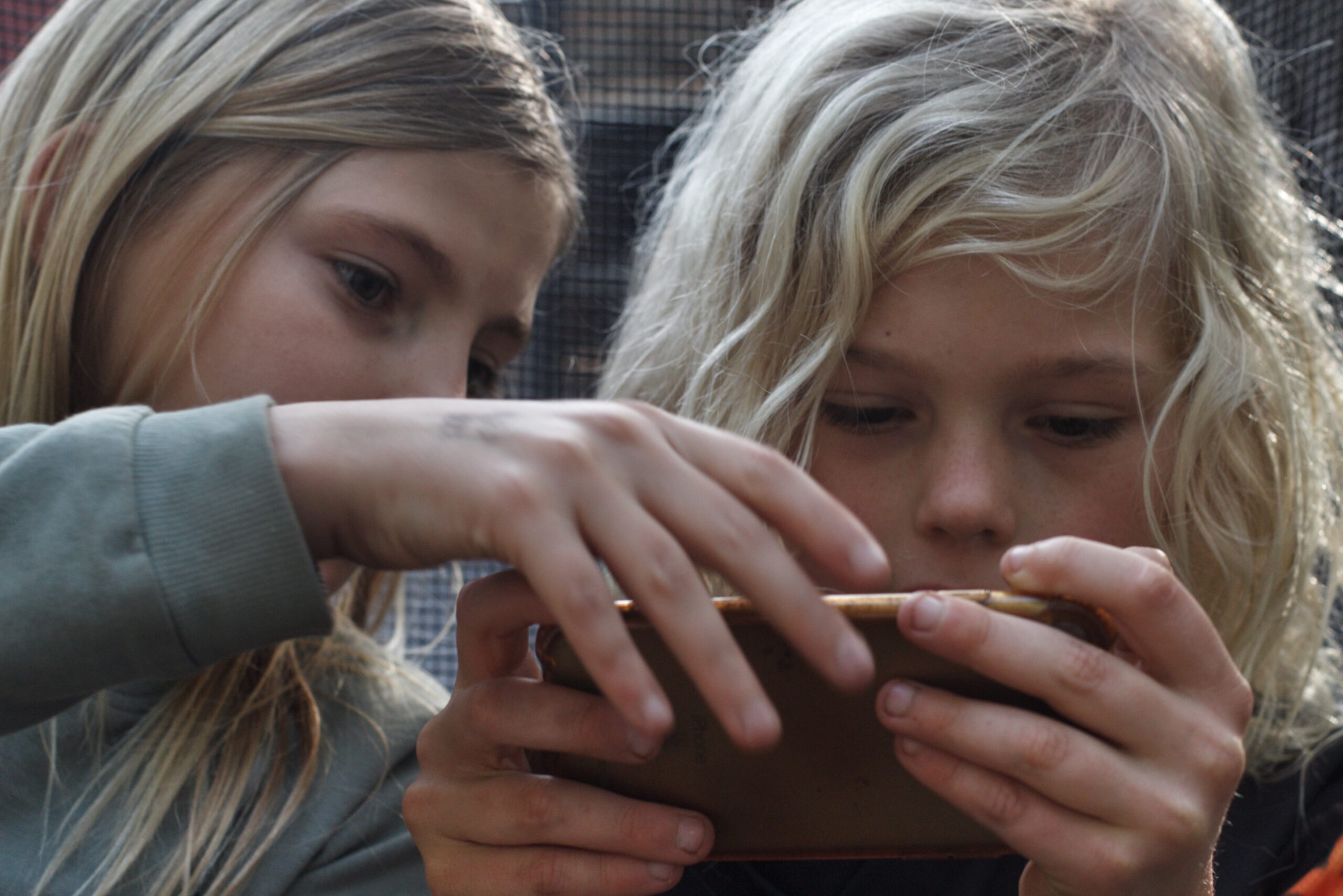 Close up of 2 kids looking at a mobile phone toget 2026 01 07 06 28 13 utc