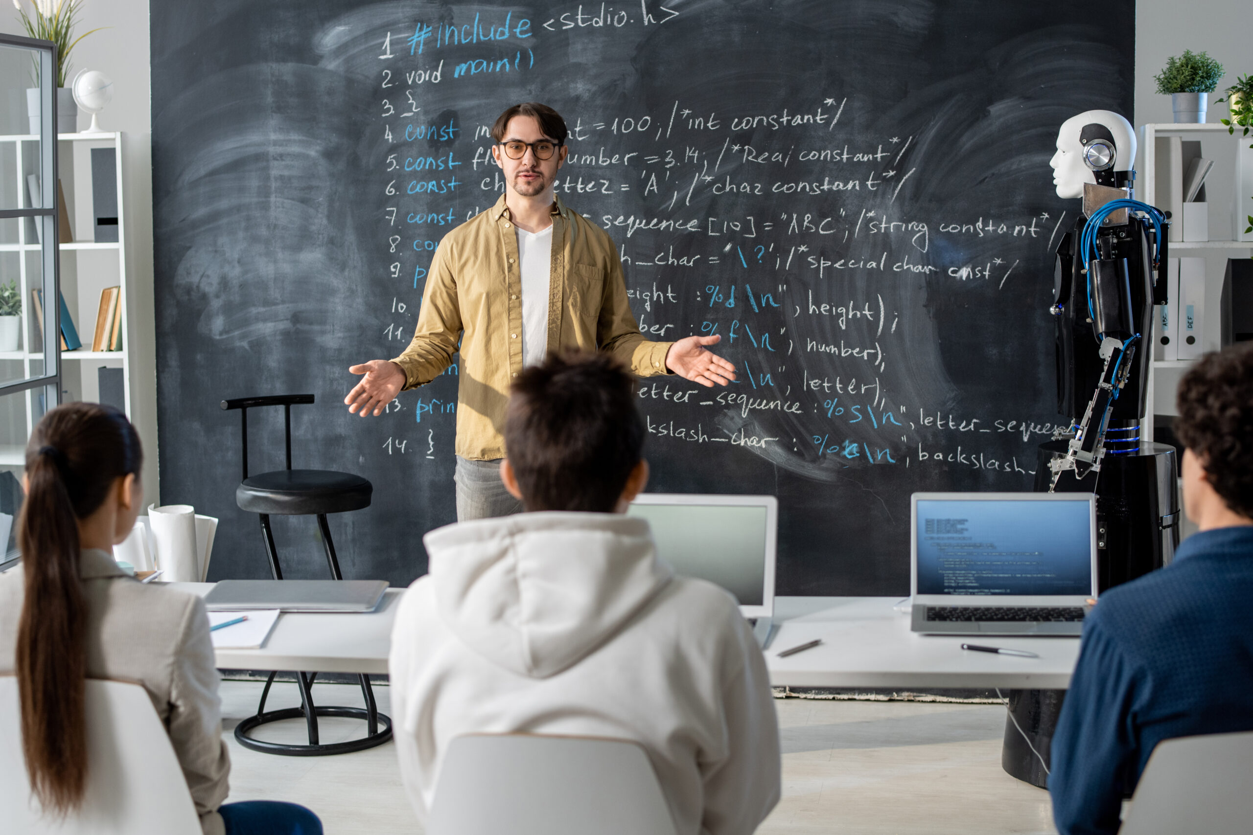 Confident teacher of modern technology course talking to students at lesson