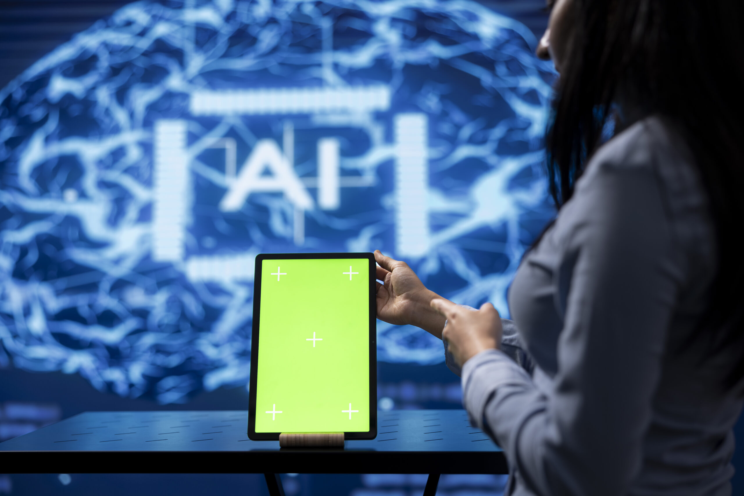 Startup coworkers brainstorming ways to use AI, using mockup tablet