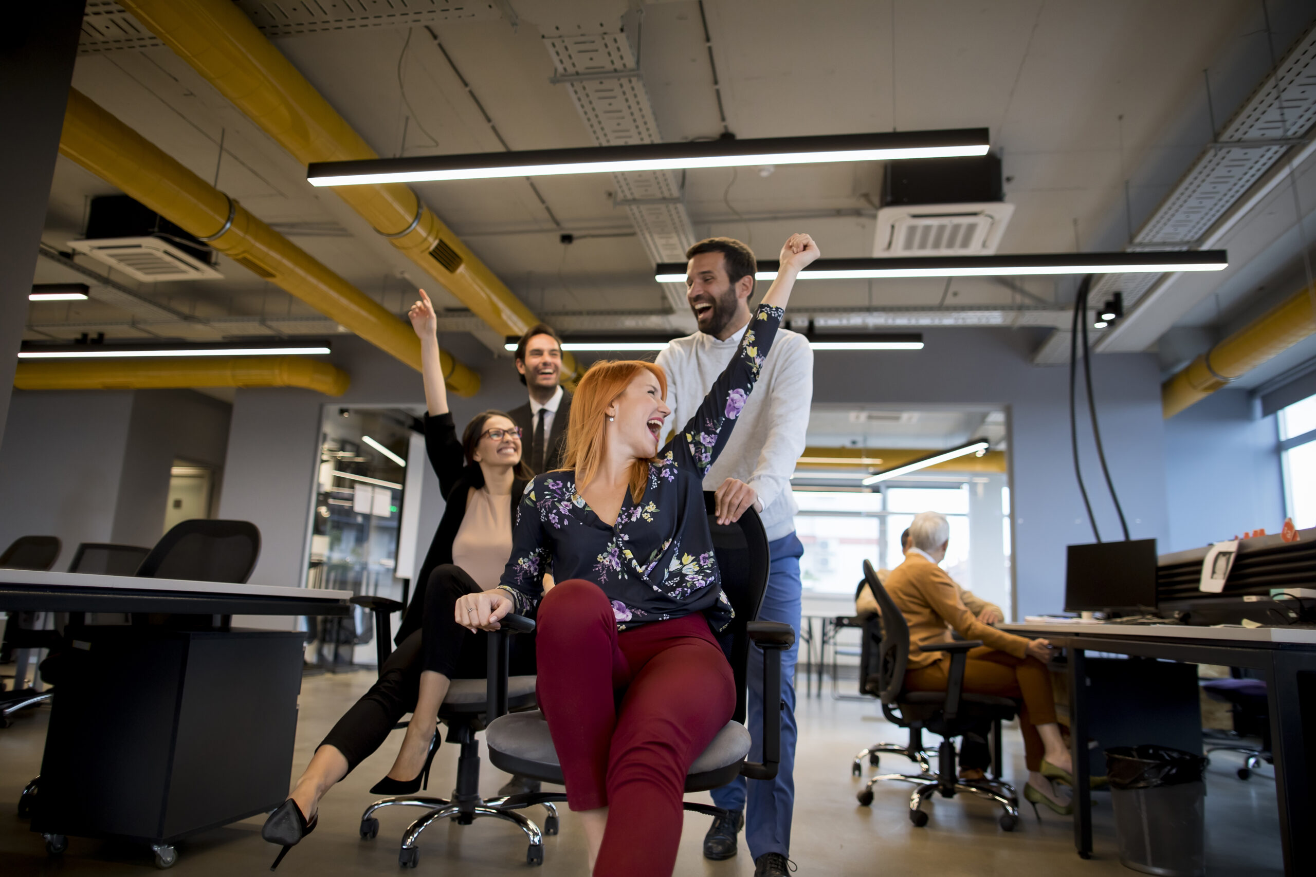 Young business people in smart casual wear having fun while raci