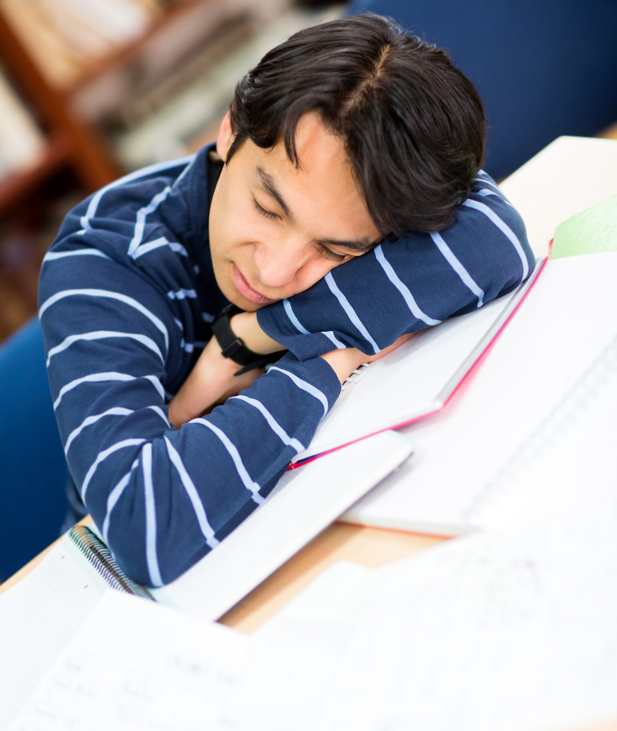 Tired male student sleeping on a pile of books 2026 01 11 09 54 31 utc