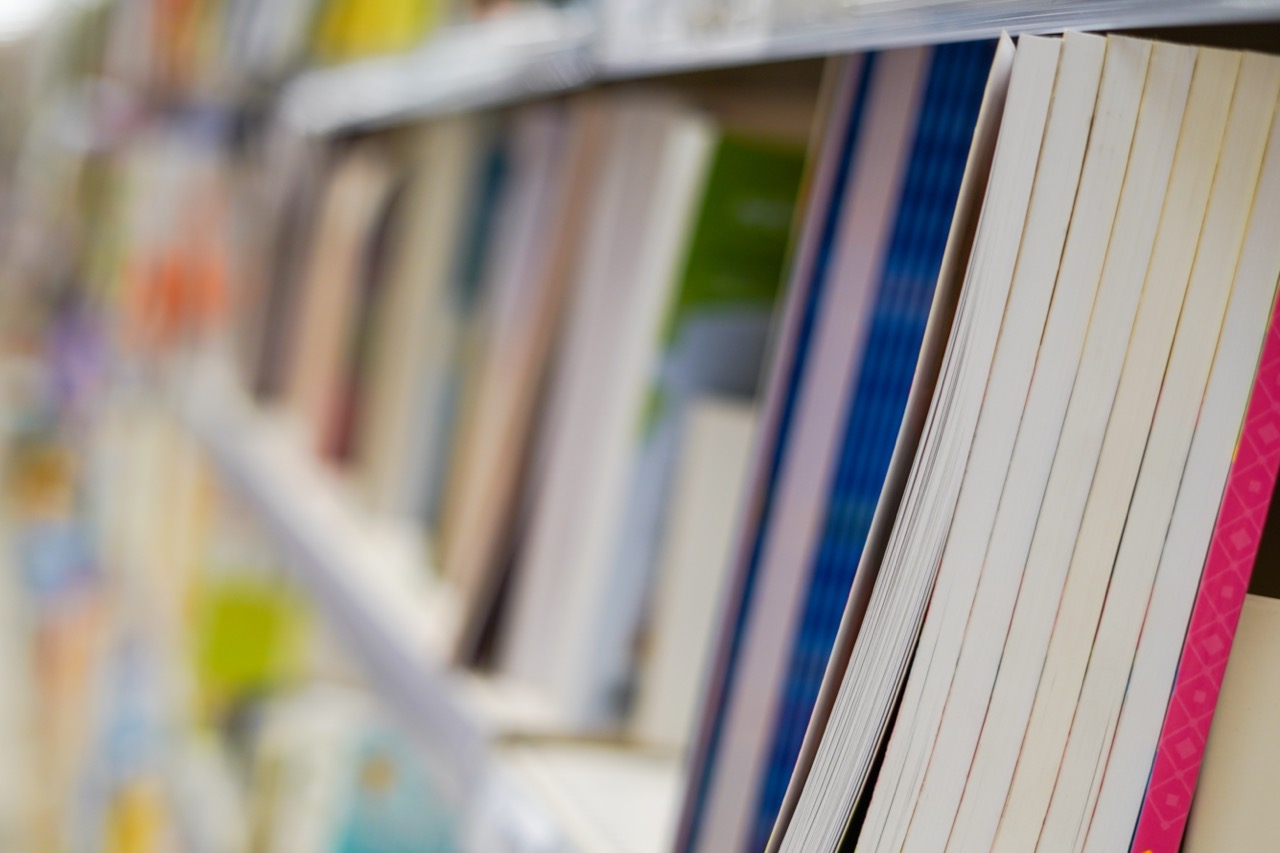 Bookstore shelf with new books. New arrivals at bookshop. Presentation of book. Copy space