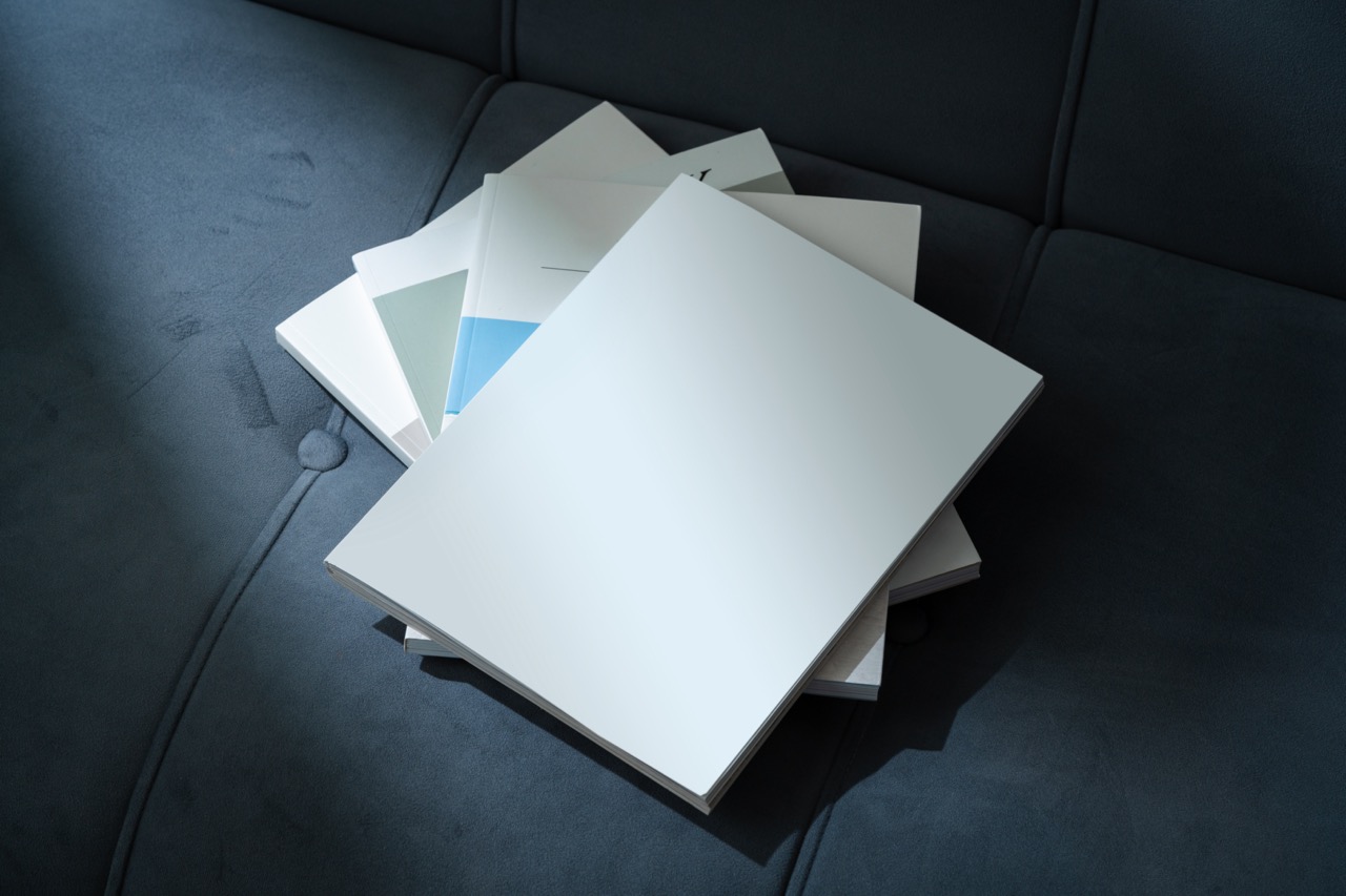 Stack of Magazines on a Black Leather Couch in Soft Light